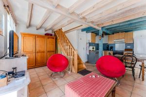 cocina y sala de estar con sillas rojas y mesa en La plage, les lacs et le calme, en Biscarrosse