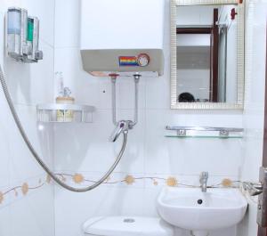 een witte badkamer met een wastafel en een douche bij LEISURE HOSTEL in Hong Kong