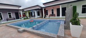 una piscina frente a una casa en Anzra Home2stay, en Kertih