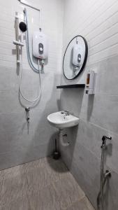 a bathroom with a sink and a mirror at Anzra Home2stay in Kertih