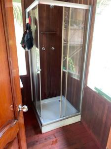 a glass shower in a room with a door at Jungle Lodge with lookout tower in Pucallpa