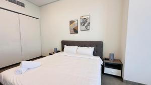 a bedroom with a large bed with white sheets at Upscale Studio Apartment Burj View with Balcony Free Parking by Belvilla in Dubai