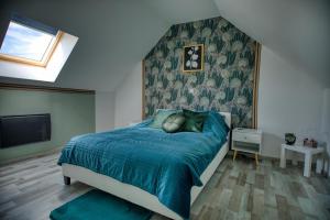 a bedroom with a bed with a blue comforter at charmante Maison de campagne in Biaches