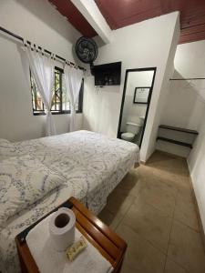 1 dormitorio con cama y baño con espejo. en Hostal MONARCA en Jamundí