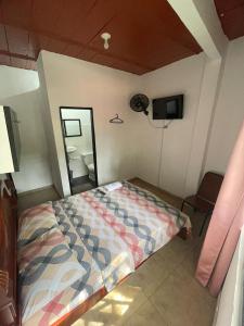 a bedroom with a bed and a mirror at Hostal MONARCA in Jamundí