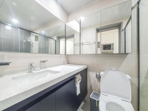 a bathroom with a sink and a toilet and a mirror at Jeju Centerpoint N Residence in Jeju