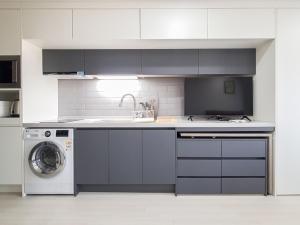 a kitchen with a sink and a washing machine at Jeju Centerpoint N Residence in Jeju