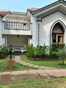 a house with a porch and a balcony at Riviera Hermitage in Anjuna