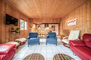 sala de estar con sofá rojo y sillas azules en Sherpa 2 - 14 pers, en Saint-Jean-dʼAulps