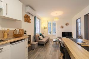 eine Küche und ein Wohnzimmer mit einer Couch und einem Tisch in der Unterkunft Maison de vacances centre ville in Ronce-les-Bains