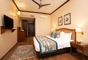 a hotel room with a bed and a television at Daleside Manor, Boutique Hotel, Kasauli in Kasauli