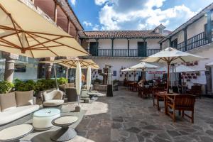 un patio con mesas, sillas y sombrillas en Casa Andina Premium Cusco, en Cusco