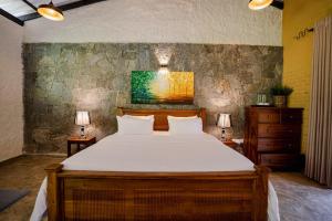 um quarto com uma cama grande e 2 candeeiros em Arsulana Eco Lodge & Spa em Ginigathena