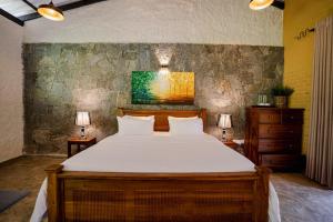 a bedroom with a large bed and two lamps at Arsulana Eco Lodge & Spa in Ginigathena