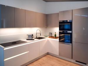 a kitchen with white cabinets and black appliances at Detached House in Zeeland with Scenic Terrace in Wemeldinge