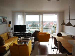 ein Wohnzimmer mit gelben Möbeln und einem großen Fenster in der Unterkunft Apartment in Nieuwpoort with balcony in Nieuwpoort