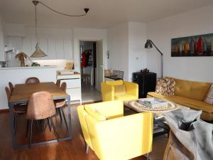 ein Wohnzimmer mit gelben Stühlen und einem Tisch in der Unterkunft Apartment in Nieuwpoort with balcony in Nieuwpoort