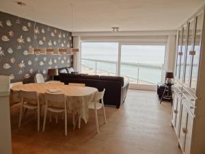 ein Esszimmer mit einem Tisch und einem Sofa in der Unterkunft Scorpio A 0901 with beautiful sea view in Nieuwpoort