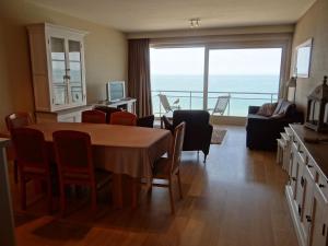 sala de estar con mesa y sillas con vistas en Scorpio A 0901 with beautiful sea view, en Nieuwpoort