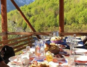 a table with food on it with a view of a mountain at Hostel Flori in Valbonë