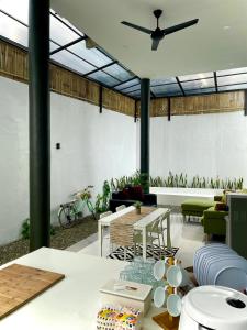 ein Wohnzimmer mit einem Deckenventilator und einem Tisch in der Unterkunft Villa Sivva Sawangan in Depok