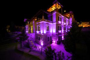 una casa con luces moradas en ella por la noche en Alaturca House en Goreme