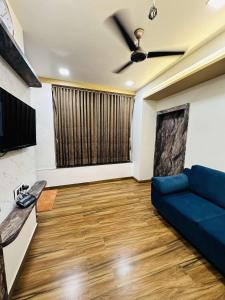 a living room with a couch and a ceiling fan at HOTEL E CLASSICO in Bhavnagar