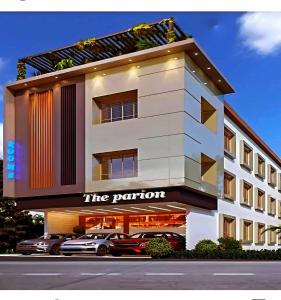 een wit gebouw met auto's ervoor geparkeerd bij The Parion Business Class Hotel in Chennai