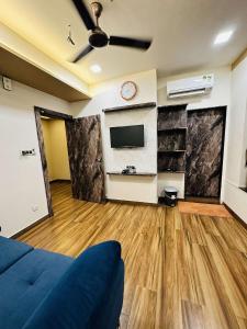 een woonkamer met een blauwe bank en een tv bij HOTEL E CLASSICO in Bhavnagar