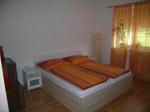 a bedroom with a bed with orange sheets and a window at Die Glocke in Anger