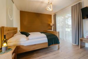 a bedroom with a bed and a large window at Monschein Weingut Straden in Straden