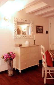 a dresser with a vase of flowers and a mirror at Albergo Diffuso Polcenigo Ca' Bianca in Polcenigo