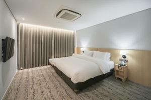 a hotel room with a bed and a television at Aank Hotel Incheon Guwol in Incheon