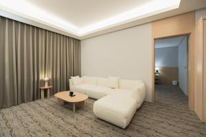 a living room with a white couch and a table at Aank Hotel Incheon Guwol in Incheon