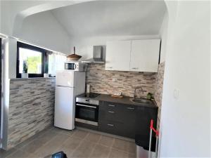 eine Küche mit einem weißen Kühlschrank und einem Herd in der Unterkunft Jona in Tribunj