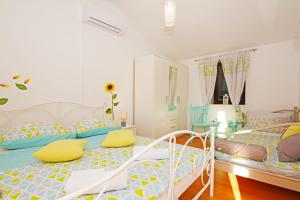 1 Schlafzimmer mit 2 Betten mit gelben und blauen Kissen in der Unterkunft Jona in Tribunj