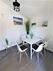 ein Esszimmer mit einem weißen Tisch und Stühlen in der Unterkunft Jona in Tribunj
