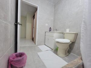 biała łazienka z toaletą i umywalką w obiekcie Rudy suite w mieście Montego Bay