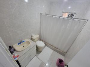 biała łazienka z umywalką i toaletą w obiekcie Rudy suite w mieście Montego Bay
