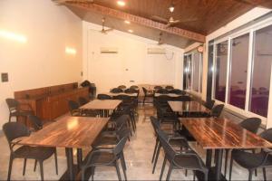 comedor con mesas y sillas de madera en ZIRAD 7BHK VILLA ALIBAUG WITH GAZEBO & POOL, en Alibaug