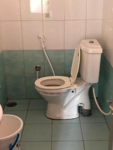 La salle de bains est pourvue de toilettes blanches. dans l'établissement Mahagiri Nest, à Mysore