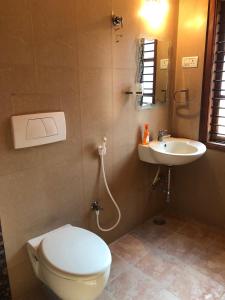 a bathroom with a toilet and a sink at Mahagiri Nest in Mysore
