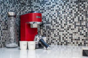 a red mixer sitting on top of a counter with cups at Best Point in the City / 2 Bedrooms in Sofia