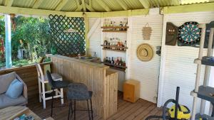 eine Bar in einem Schuppen mit zwei Stühlen und einem Tisch in der Unterkunft La libellule caribéenne in Sainte-Rose