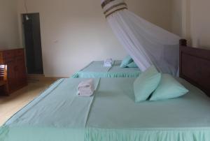 1 dormitorio con 2 camas individuales y almohadas azules en Jungle Treking In Bukit Lawang Booking with us, en Timbanglawang