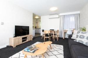 una sala de estar con un sofá y una mesa en CBD Apartment by the Park: WiFi & Parking, en Launceston