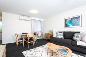 una sala de estar con un sofá y una mesa en CBD Apartment by the Park: WiFi & Parking, en Launceston