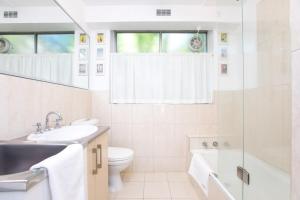 a bathroom with a sink and a toilet and a shower at CBD Apartment by the Park: WiFi & Parking in Launceston