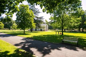 un parque con un banco en el césped en CBD Apartment by the Park: WiFi & Parking, en Launceston