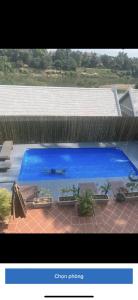 a large blue swimming pool with benches and a fence at Villa Namkhan River in Luang Prabang